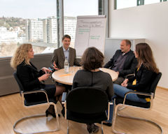 Das Bild zeigt fünf Personen in der Gesprächsrunde beim Güterichterverfahren